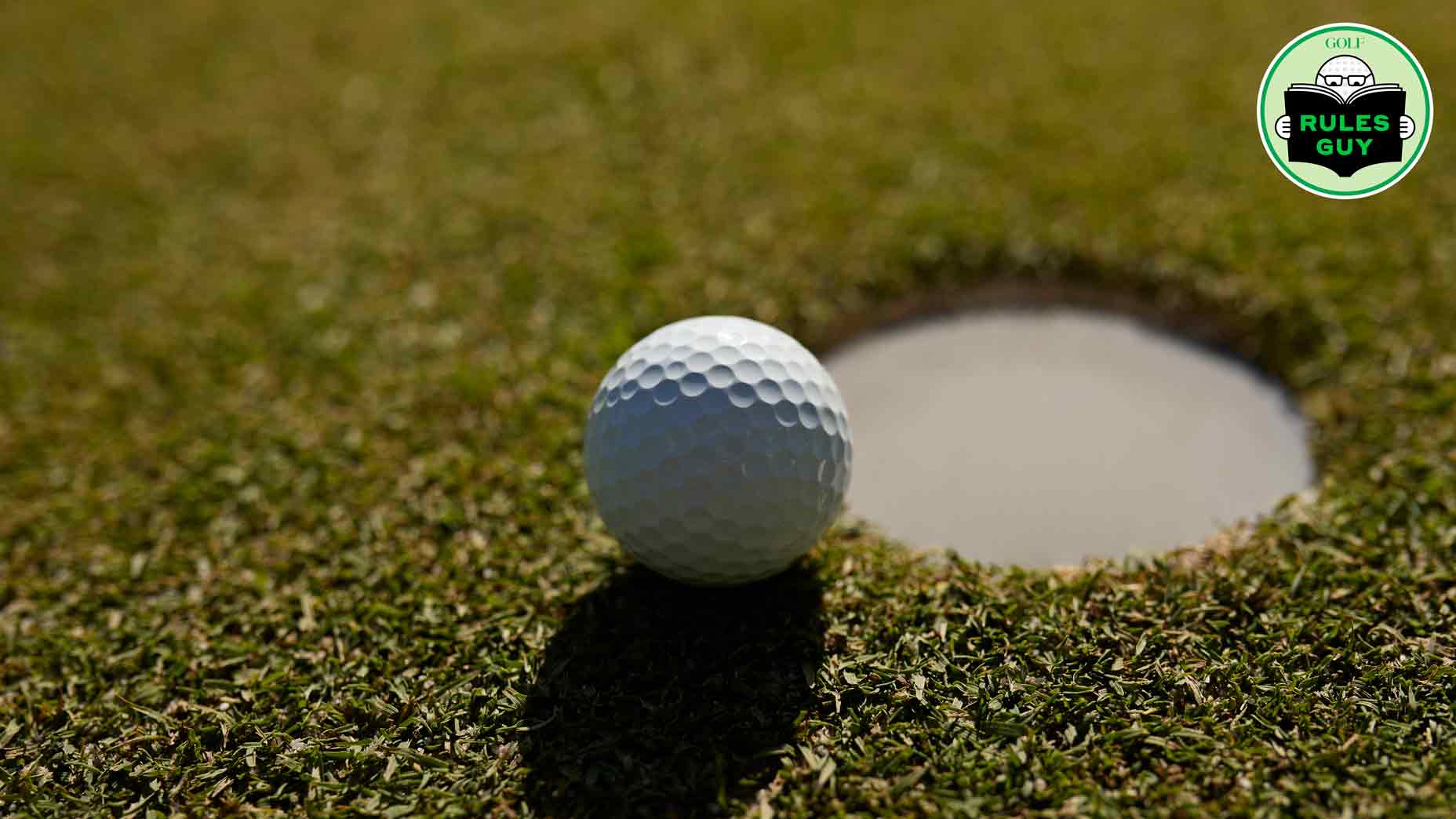 Close-up of golf ball near hole at course