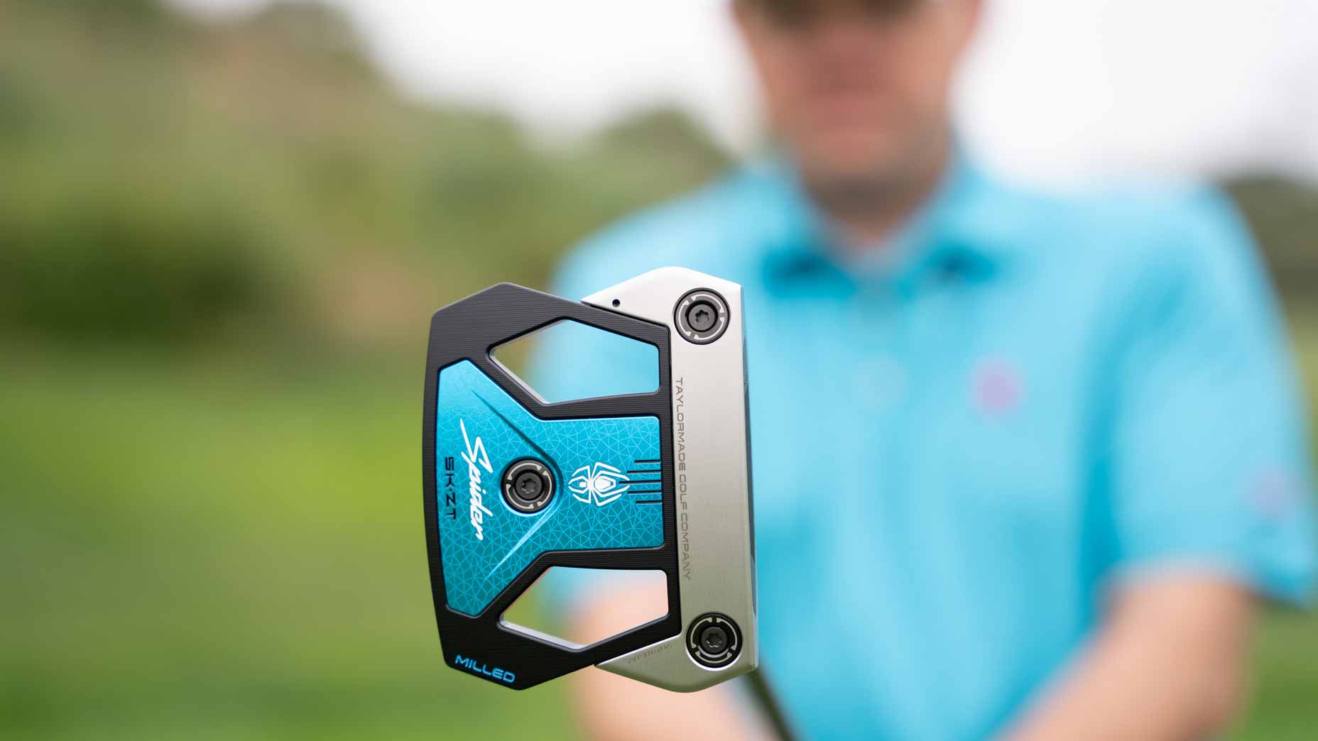 Golfer holds TaylorMade Spider ZT putter.