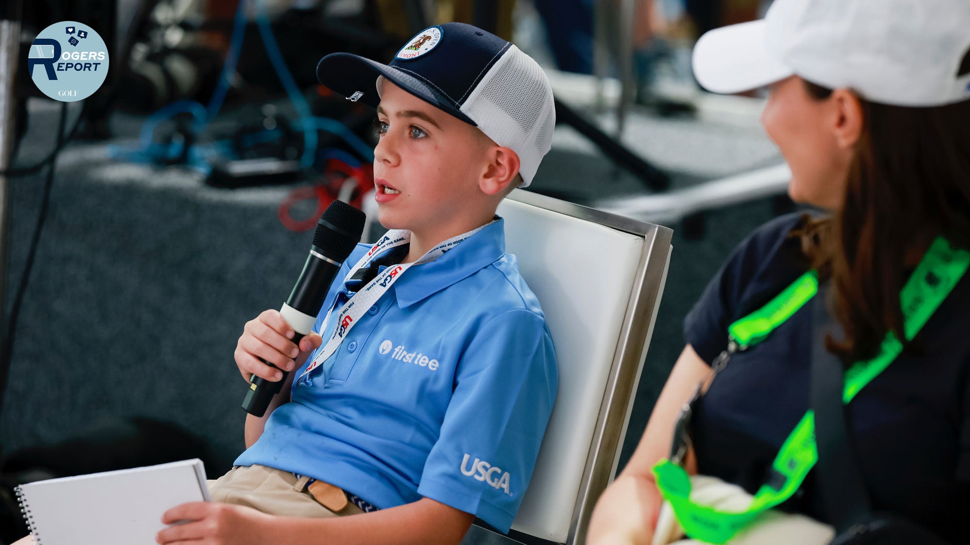 Sentry First Tee junior course reporter Silas asks Bryson DeChambeau a question.